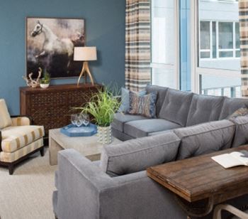 A living room featuring high ceilings and expansive double pane windows with natural lighting